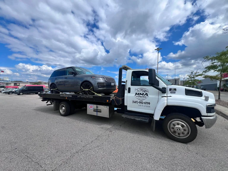 MMA Towing flatbed truck transporting an SUV across the Greater Toronto Area